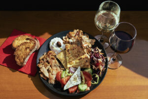 Mykonos boat trip lunch platter with chicken and pork gyros, fresh Greek salad, feta cheese, and tzatziki.