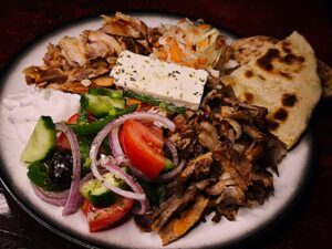 Mykonos boat trip lunch platter with chicken and pork gyros, fresh Greek salad, feta cheese, and tzatziki.