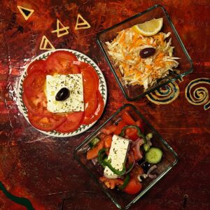 Homemade Greek salad with local feta cheese, olives, and extra virgin olive oil served on the wooden deck of Calypso motorsailer